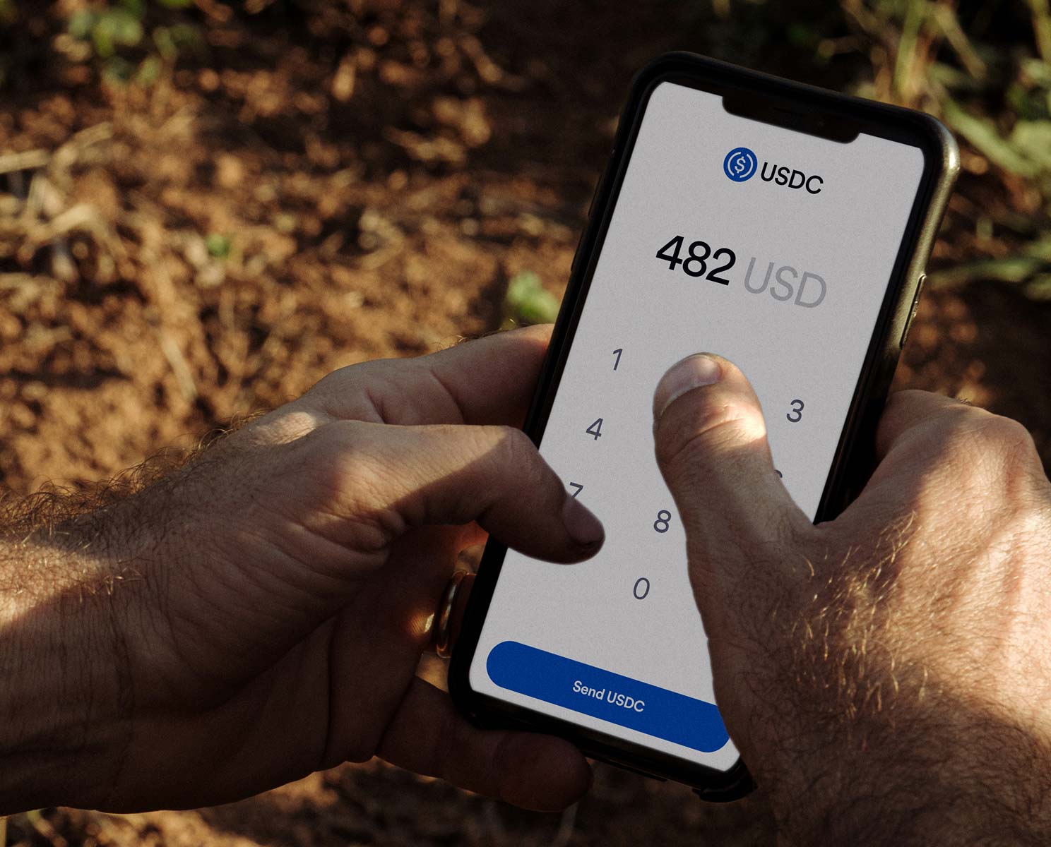 Photo of someone using an app to send USDC